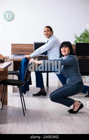The two employees doing sport exercises in the office Stock Photo