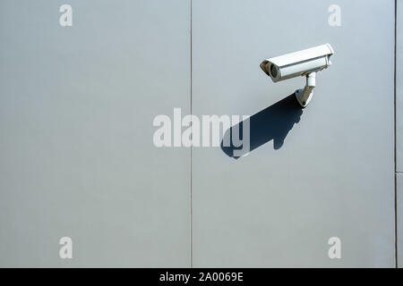 Surveillance wall mounted outdoor camera with harsh daylight shadow and copy space Stock Photo