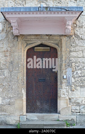 wooden door of 3 Holywell Street in Oxford with modern intercoms and Roman numerals carved in stone above. Once a girls' school now part of  Merton Stock Photo