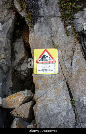 Tenby, Wales – August 26, 2019: Beware Danger of falling rocks sign on a beach in Tenby, United Kingdom Stock Photo