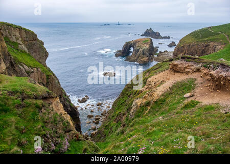 Grassy cliffs overlooking Enys Dodnan Arch Stock Photo