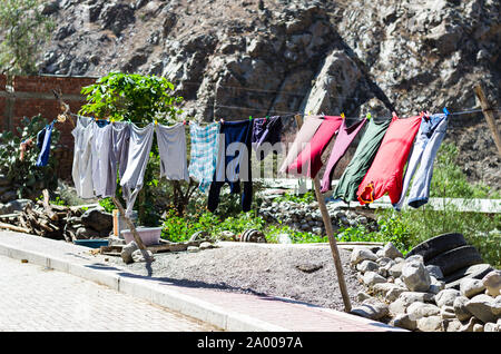Rope with clean clothes outdoors on laundry day. Stock Photo