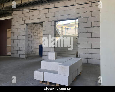 Piled cinder blocks on the floor of the prefabricated multi-storey building at the construction site. Stock Photo