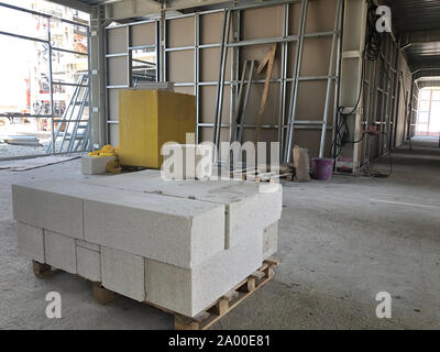 Piled cinder blocks on the floor of the prefabricated multi-storey building at the construction site. Stock Photo