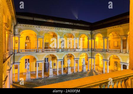 Illuminated courtyard with loggia and sculptures, University of Pavia, night scene, Pavia, Lombardy, Italy Stock Photo