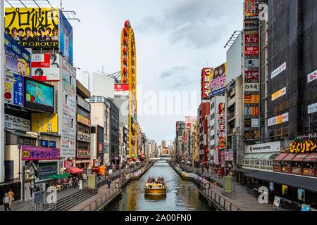 Tourist boat on the Dotonbori canal, illuminated advertising and many signs, Dotonbori, Osaka, Japan Stock Photo