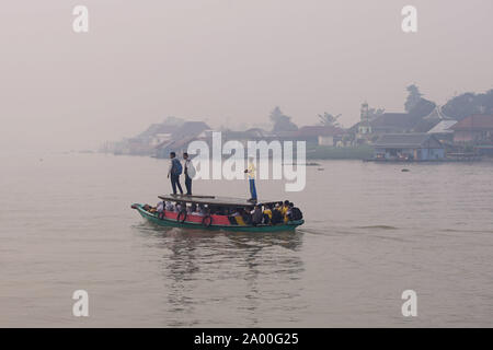 Beijing, Indonesia. 17th Sep, 2019. Pupils ride boat across Musi River under a blanket of smoke in Palembang, South Sumatra, Indonesia, Sept. 17, 2019. Forest fires often occur in Indonesia as growers use fire to clear lands to make room for new plantation. But the fires often rage out of control especially during the dry season. Thick haze from a forest fire in Indonesia spreading into Malacca Strait, Singapore and Malaysia was detected by a satellite image on Sept. 14, the Indonesian meteorology and geophysics agency said. Credit: Muhammad Fadjrie /Xinhua Stock Photo