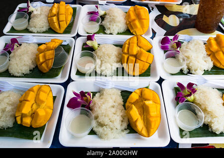 Asian snack sticky rice with mango. Market hawker stall with traditional street food Stock Photo