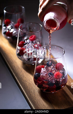 Drink being poured into glasses with berries Stock Photo