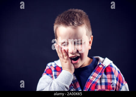 A boy feels strong tooth ache. Children, healthcare and medicine concept