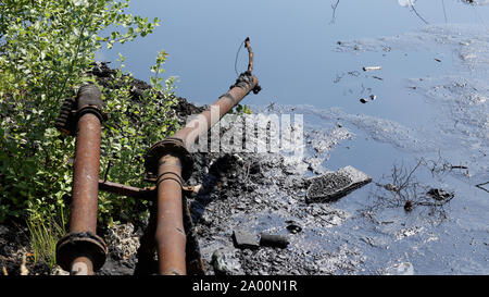 Former dump toxic waste, effects nature from contaminated soil and water with chemicals and oil, environmental disaster, contamination, pipes Stock Photo