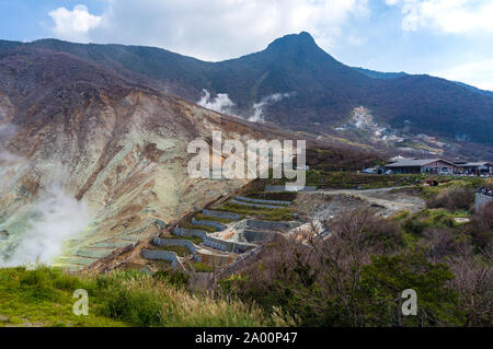 Terrace slopes of Owakudani with unidentified people. Owakudani is a volcanic valley with active sulphur vents and hot springs. It is popular tourist Stock Photo