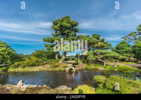 Kanazawa, Ishikawa Japan - August 22, 2018 : Japanese pine trees and a Stone Lantern (Ishidoro) inside a pond at Kenrokuen Garden Stock Photo