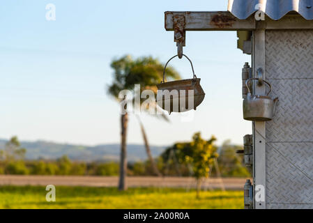 Antique objects hung on the handle of a trailer and that serve as crafts and decoration of environments. Ima Iron pot and an old kettle depended on a Stock Photo