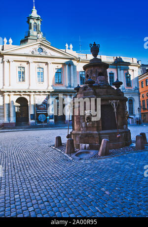 Nobel Museum and Stortorgsbrunnen (well) in cobbled medieval square Stortorget, Gamla Stan, Stockholm, Sweden Stock Photo