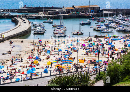the view from Langmoor and Lister gardens, down onto the harbour enclosed by the Cobb in Lyme Regis, on a clear sunny summer day Stock Photo