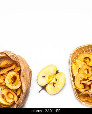 Tasty dried apples chips isolated on white background, in paper bags and fresh half apple, copy space Stock Photo