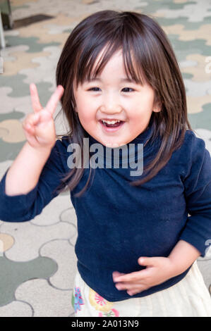 A routine occurrence on the streets of Tokyo, a friendly peace sign greeting to welcome me to Japan. Stock Photo