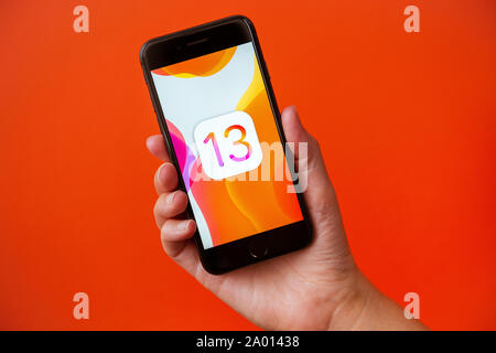 Kyiv, Ukraine - September 19, 2019: Studio shot of hand holding Apple iPhone 8 with an abstract wallpaper image about the release of the new iOS 13 Stock Photo