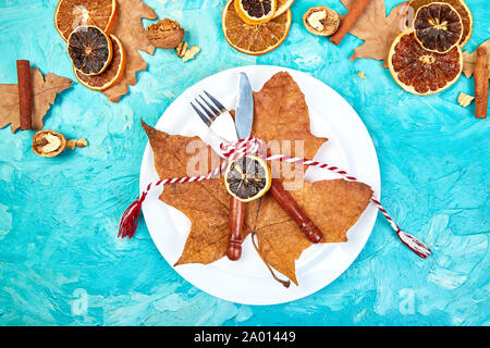 Autumn or Fall table place setting decorated with autumnal leaves. Stock Photo