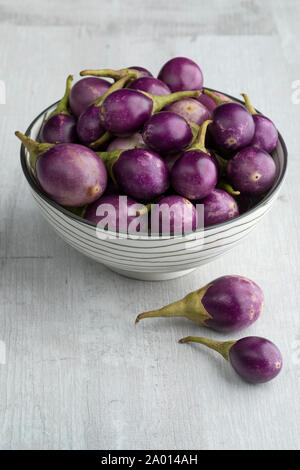 Bowl with fresh raw purple mini eggplants as a snack Stock Photo