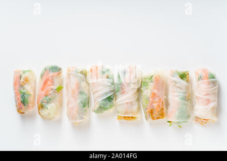 Vegetarian spring rolls with tofu, marinated carrot and daikon and cilantro on white background with copy space Stock Photo