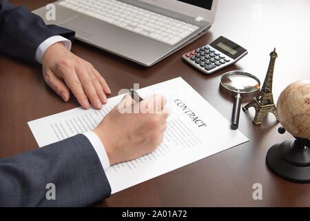 Hand of businessman holding pen in hand and signing contract document. Stock Photo
