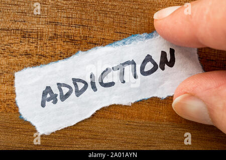 The word Addiction concept and theme written on old paper on a grunge background Stock Photo