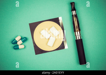 Nicotine patch, drugs, chewin gum and ecigarette used for smoking cessation isolated on green background Stock Photo