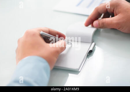Picture of man working paperwork with a pen. Isolated on a white background. Stock Photo