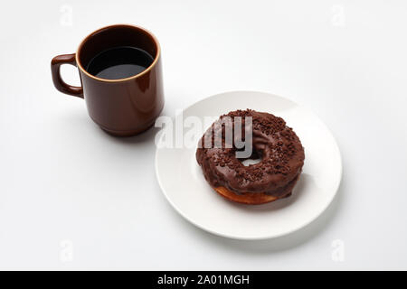chocolate frosted doughnut on plate with hot coffee closeup isolated on white background Stock Photo