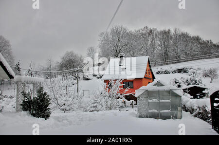 snow covered garden with house in winter Stock Photo