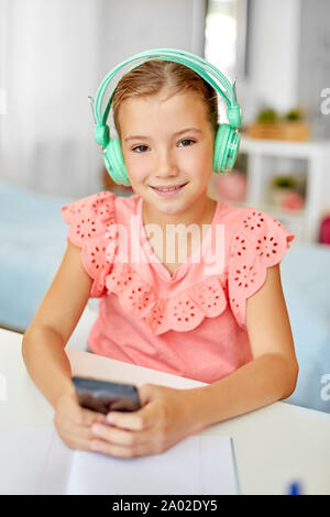 girl in headphones listening to music on cellphone Stock Photo