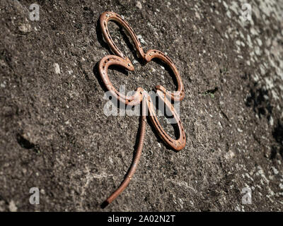 Closeup of a cloverleaf on a rock made of horseshoes Stock Photo