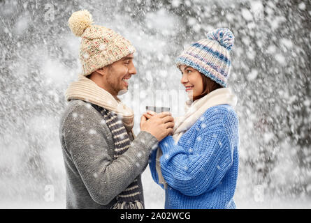 happy couple in winter clothes holding one cup Stock Photo