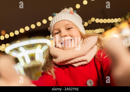 little girl taking selfie at christmas market Stock Photo