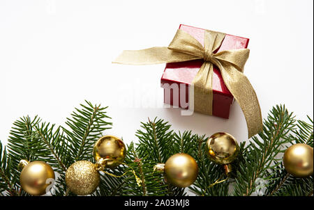 Christmas present. Fir twig fresh and red gift box with gold ribbon against white color background, copy space Stock Photo