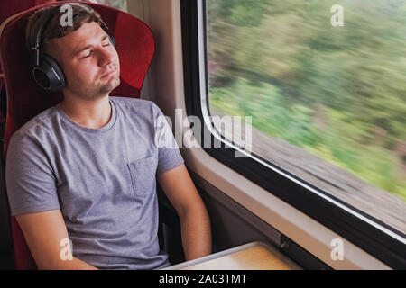 Young man in headphones sitting with his eyes closed Stock Photo