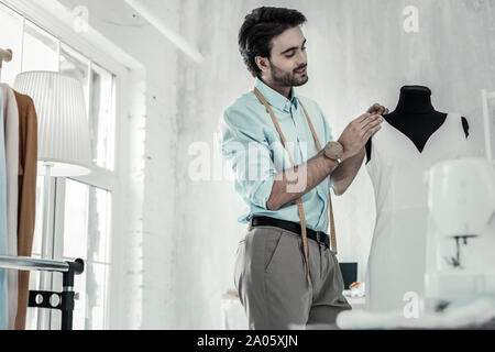 Professional young stylist working with white textile Stock Photo