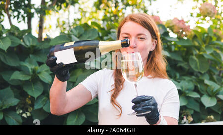 Female bartender pouring champagne into glass, close-up outdoors. Concept about drink, alcohol and restaurant service, catering Stock Photo