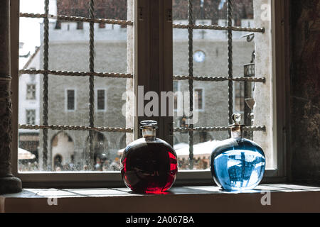 Two bottles with red and blue liquid on the window sill of the old pharmacy, Tallinn, Estonia. Stock Photo