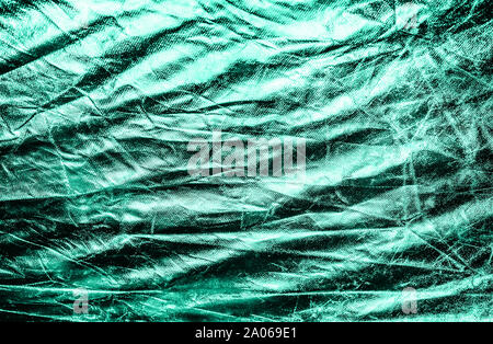 Textured silver foil background with shiny crumpled surface in trendy mint color. Stock Photo