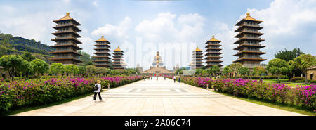 Kaohsiung, Taiwan: Panorama view of the Fo Guang Shan Buddha with the Pagodas on both sides and tourists walking towards the Buddha statue Stock Photo