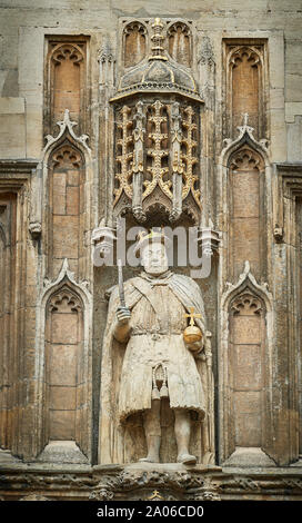 Statue of king Henry VIII with stool leg (instead of a sceptre) and orb in niche above entrance to Trinity college, university of Cambridge, England. Stock Photo