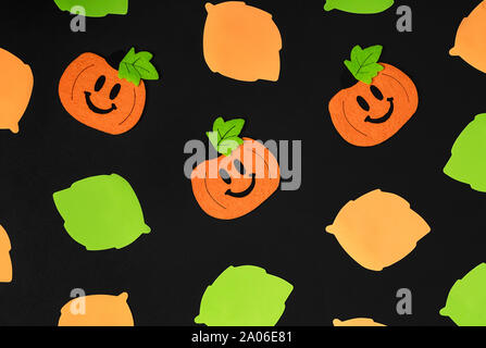 Background of halloween theme decorations. Toy pumpkins and assortment of leaves on black backdrop. Flat lay style. Copy space. Copy space. Flat lay s Stock Photo