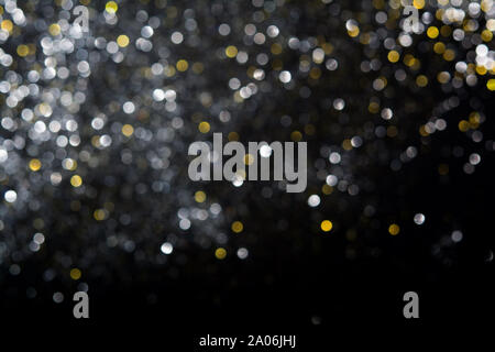 Abstract blurred glitter bokeh background in silver and gold, on black Stock Photo