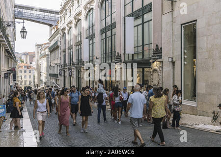 Lisbon, Portugal – august, 2019: tourists walking at pedestrian street Rua do Carmo at Baixa district in downtown. On background the iron structure of Stock Photo