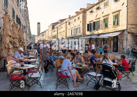 Dubrovnik cafe; people sitting having a drink outside at cafes on Stradun, the main street, Dubrovnik old town, Dubrovnik Croatia Europe Stock Photo
