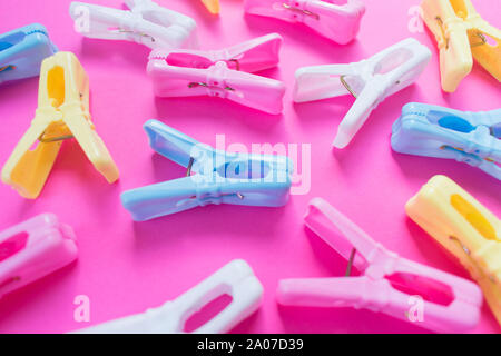 Colored clothespins on a bright pink background. Background, view from the top. Stock Photo