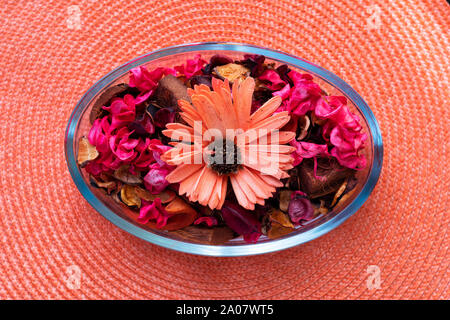 Dried petals flowers It is placed in a decorative bowl.on the orange mat Stock Photo